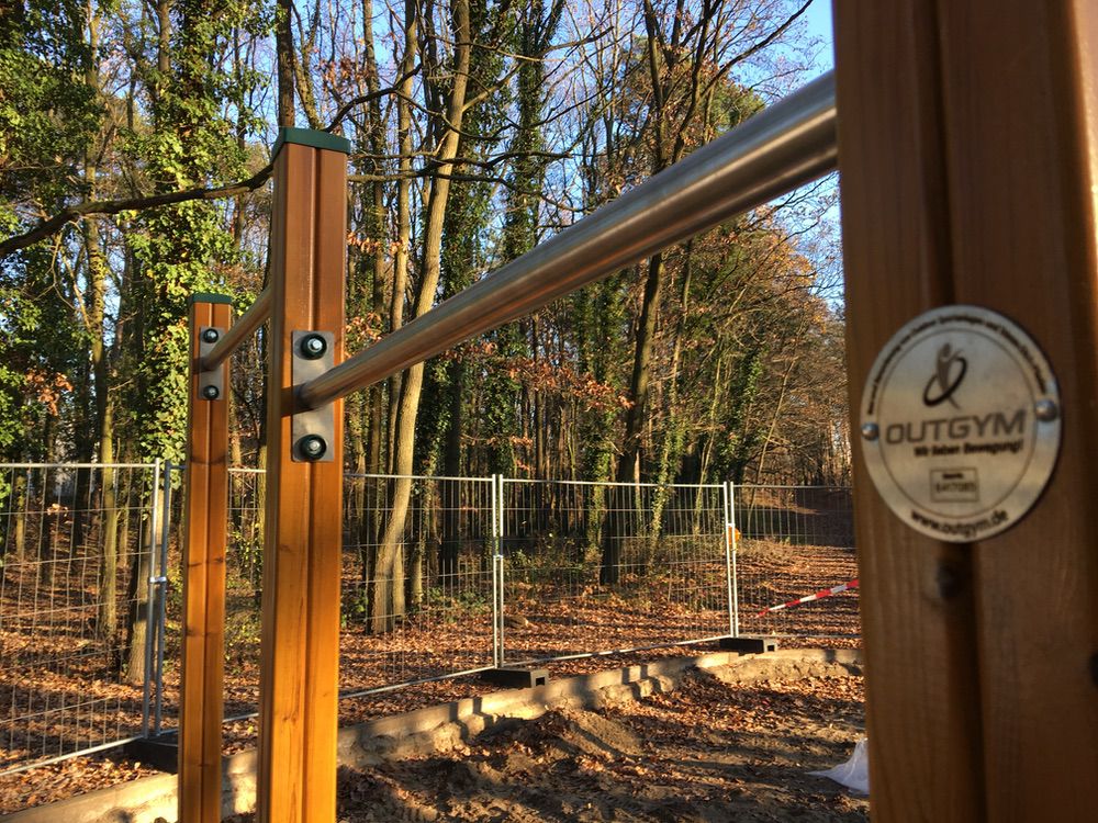 Outdoor-Fitness: Outgym Recks im herbstlichen Waldlandschaft mit Holz- und Metallelementen.