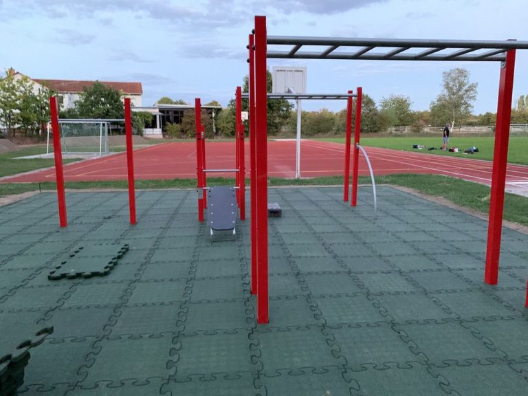 Outdoor Fitness- und Laufstrecke mit Calisthenics-Geräten in grüner Umgebung.