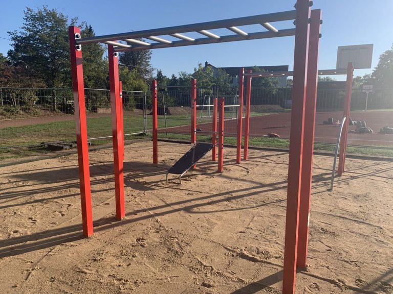 Spielplatz mit Klettergerüst, Rutsche, Basketballkorb, Bäumen, nahe Wohngebieten, Schwetzingen.